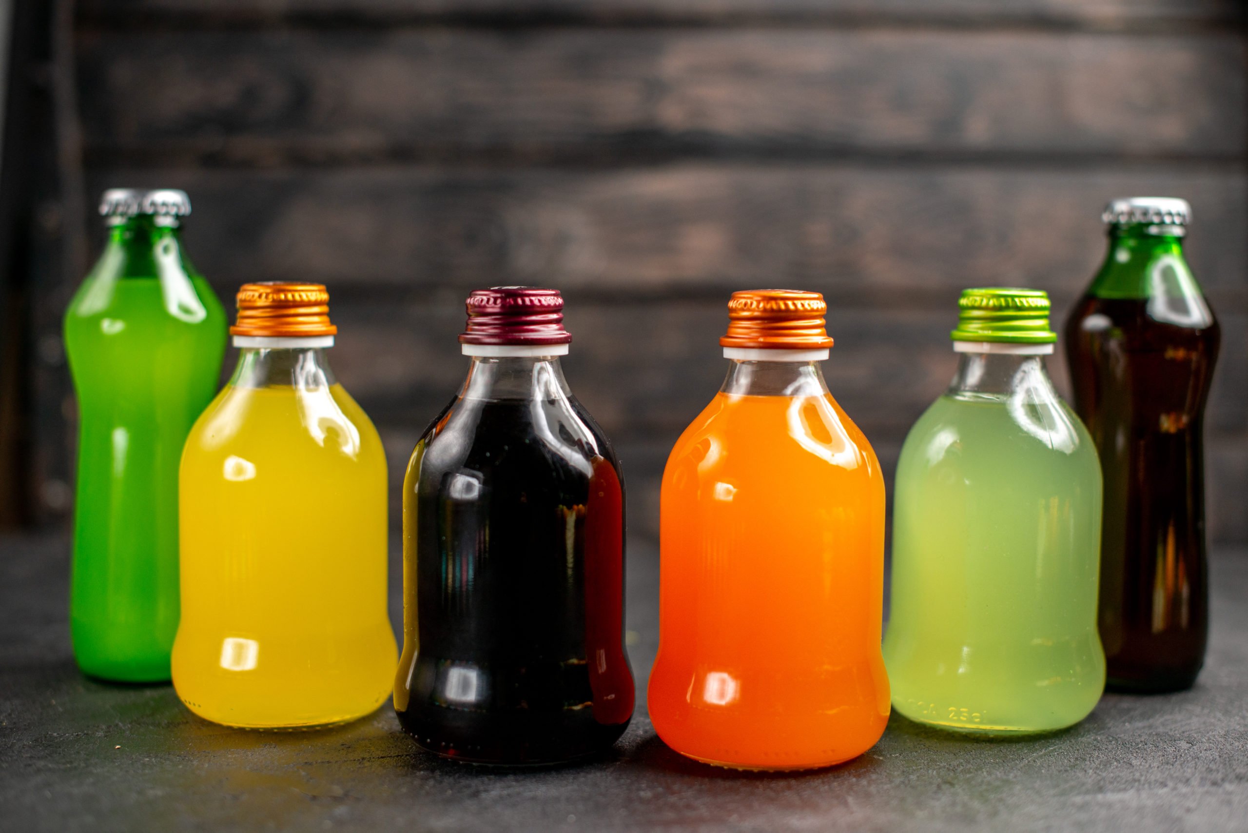 front-view-juices-of-different-colors-on-dark-islated-surface